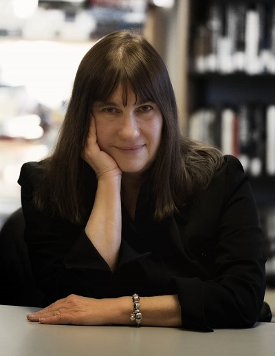 Photo of Karen Shenfeld, leaning on a table.